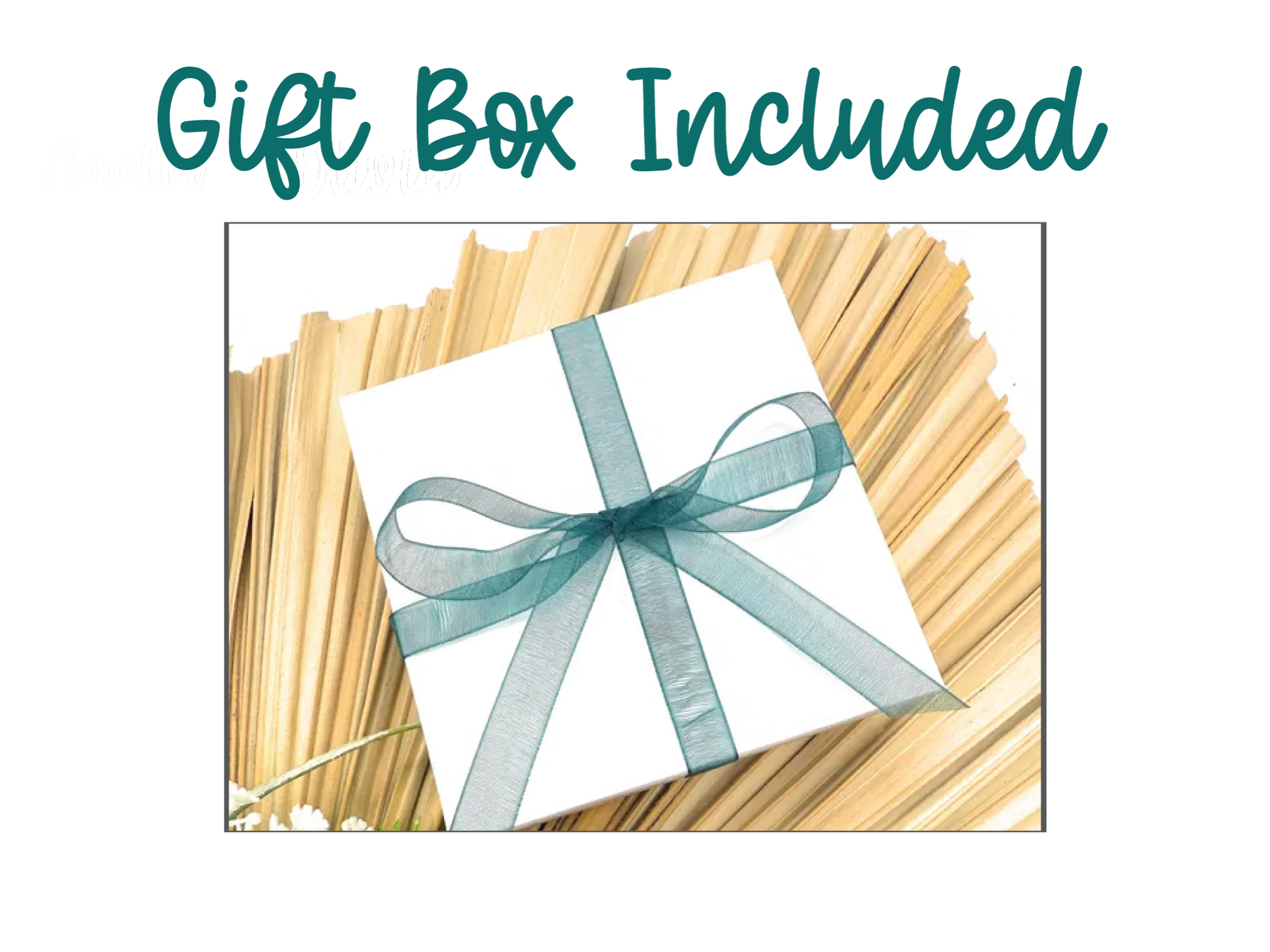 A gift box with a green ribbon tied around it, placed on a bed of straw or straw-like material.